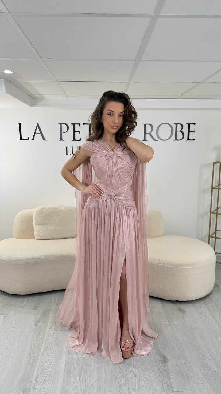 Robe de soirée rose élégante longue, col en V drapé, sans manche et dotée d’une fente raffinée. Coupe fluide et féminine idéale pour mariages et cérémonies.