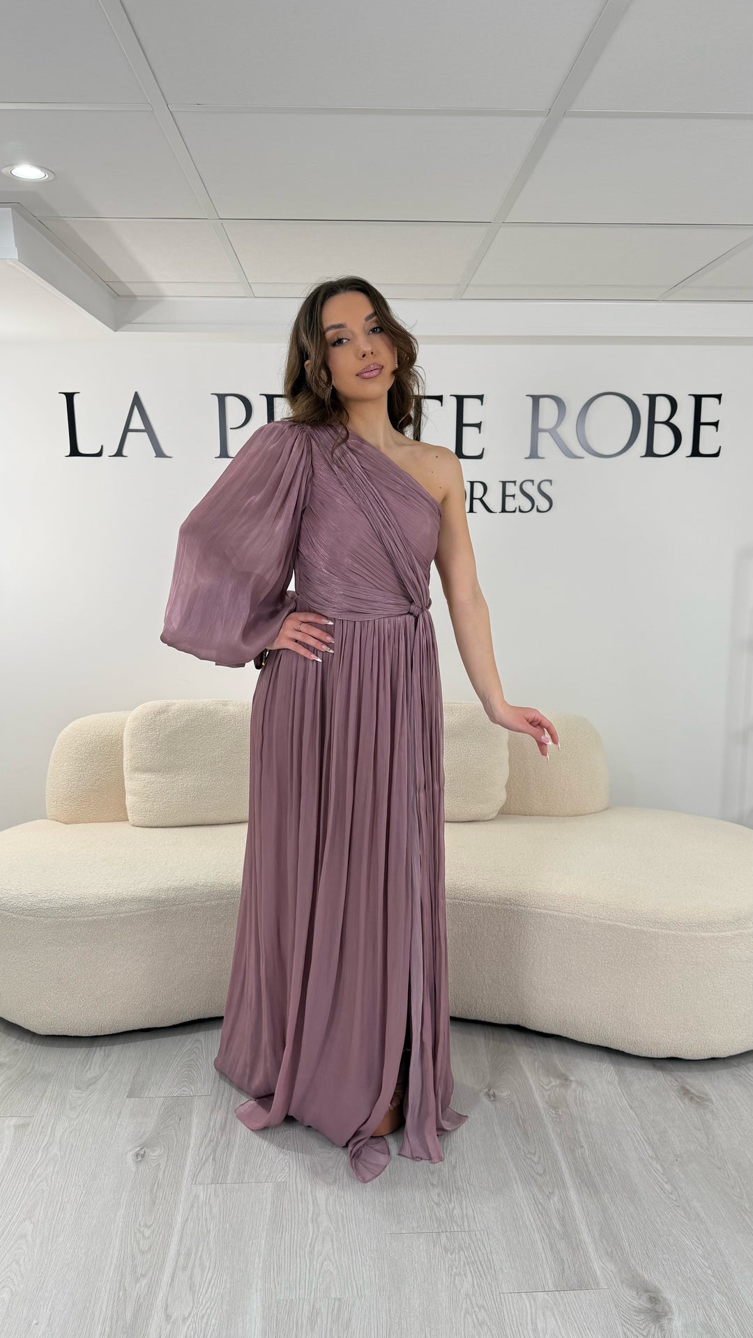 Robe de soirée vieux rose longue avec col asymétrique, une manche fluide et un bras sans manche, dotée d’une fente élégante. Parfaite pour mariage et gala.
