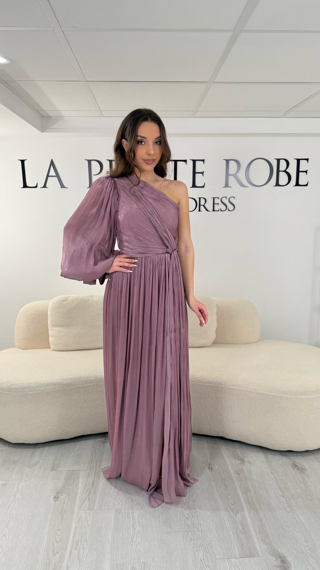 Robe de soirée vieux rose longue avec col asymétrique, une manche fluide et un bras sans manche, dotée d’une fente élégante. Parfaite pour mariage et gala.