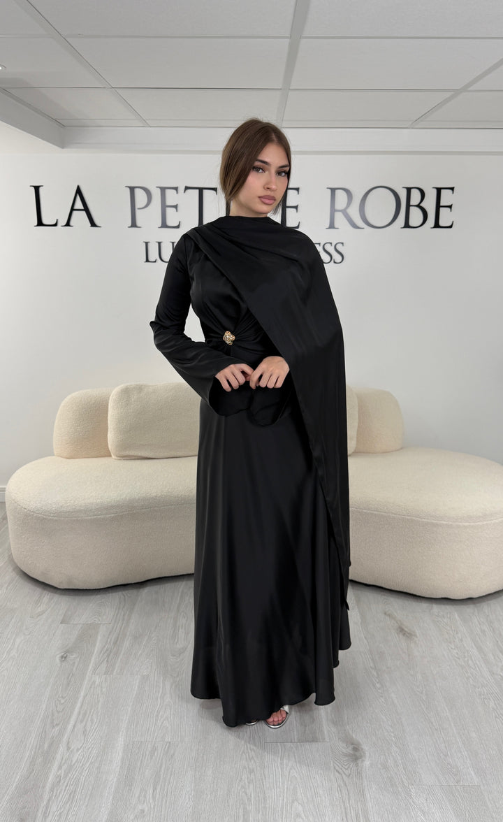 Robe de soirée modeste noire longue avec col rond, manches longues et drapé élégant. Une robe sans fente idéale pour mariage, cérémonie ou demoiselle d'honneur.
