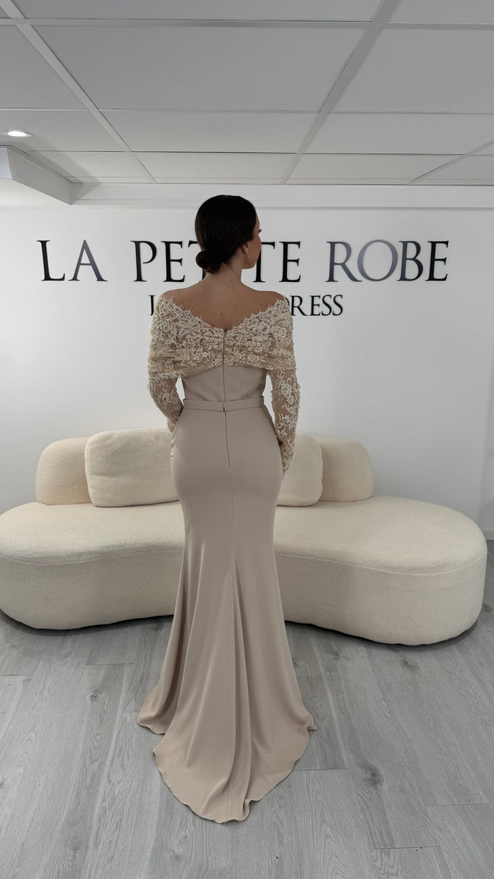 Robe de soirée beige élégante avec col bateau en dentelle et manches longues. Robe longue sans fente idéale pour soirée chic.