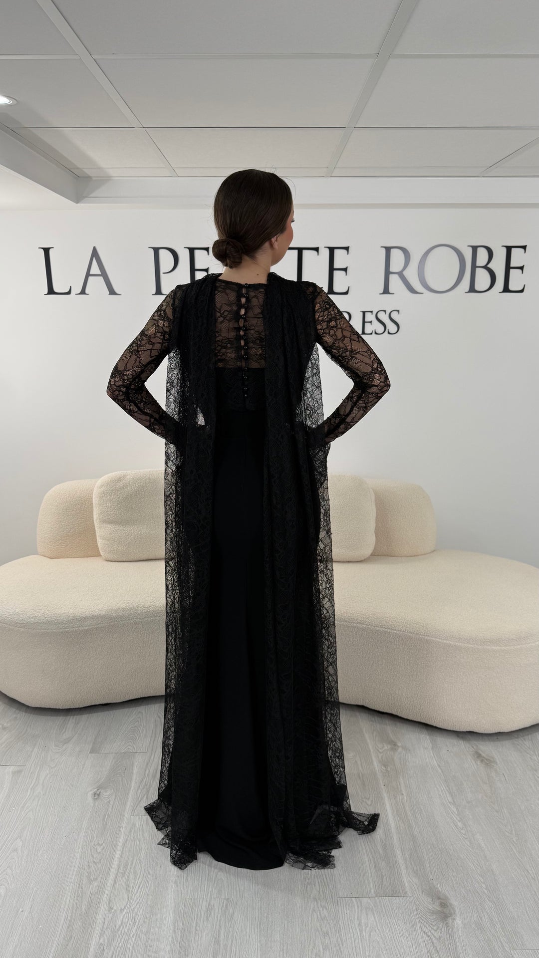 Robe de soirée noire élégante avec boléro en dentelle amovible et écharpe assortie. Robe longue sans fente idéale pour cérémonie et soirée chic.
