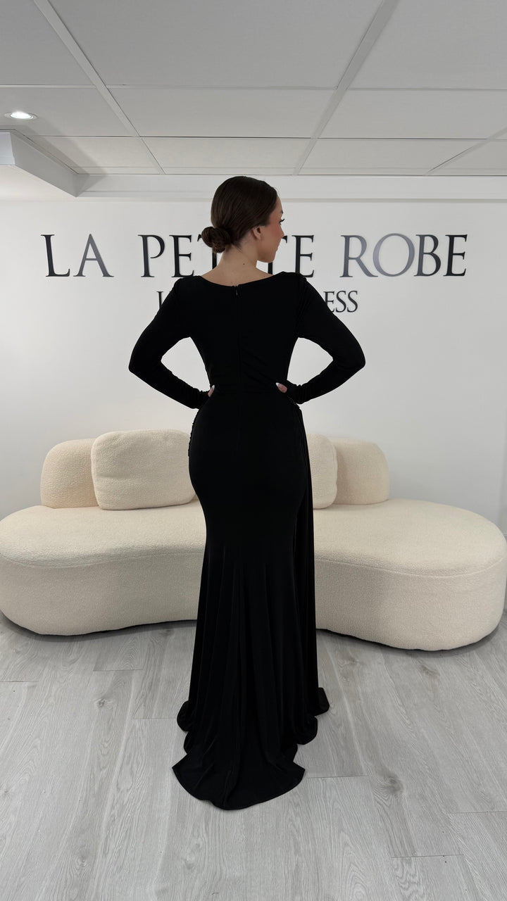 Robe de soirée noire élégante avec col bateau drapé et manches longues. Robe longue sans fente idéale pour soirée chic.