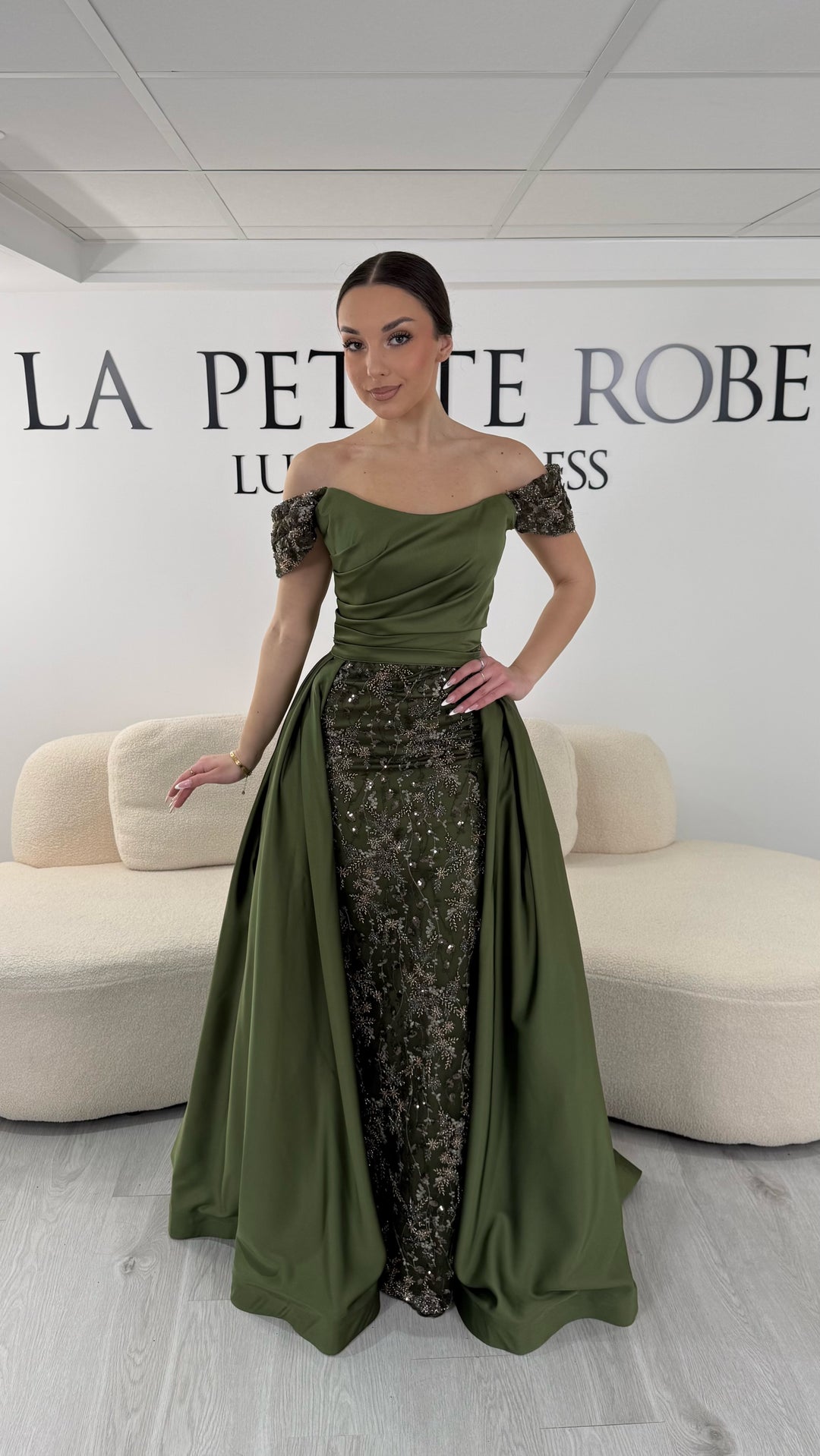 Robe de soirée kaki élégante sans manches avec col bardot et sequins. Robe longue sans fente idéale pour soirée chic.