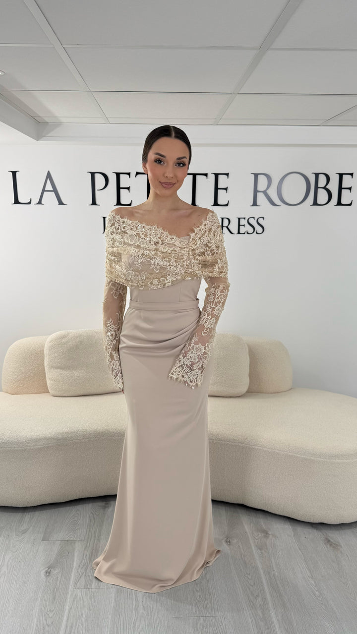 Robe de soirée beige élégante avec col bateau en dentelle et manches longues. Robe longue sans fente idéale pour soirée chic.