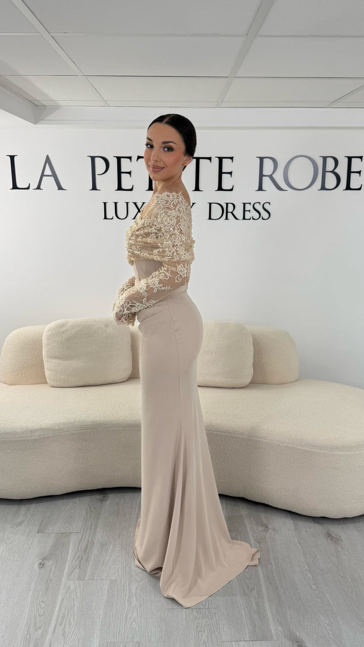 Robe de soirée beige élégante avec col bateau en dentelle et manches longues. Robe longue sans fente idéale pour soirée chic.