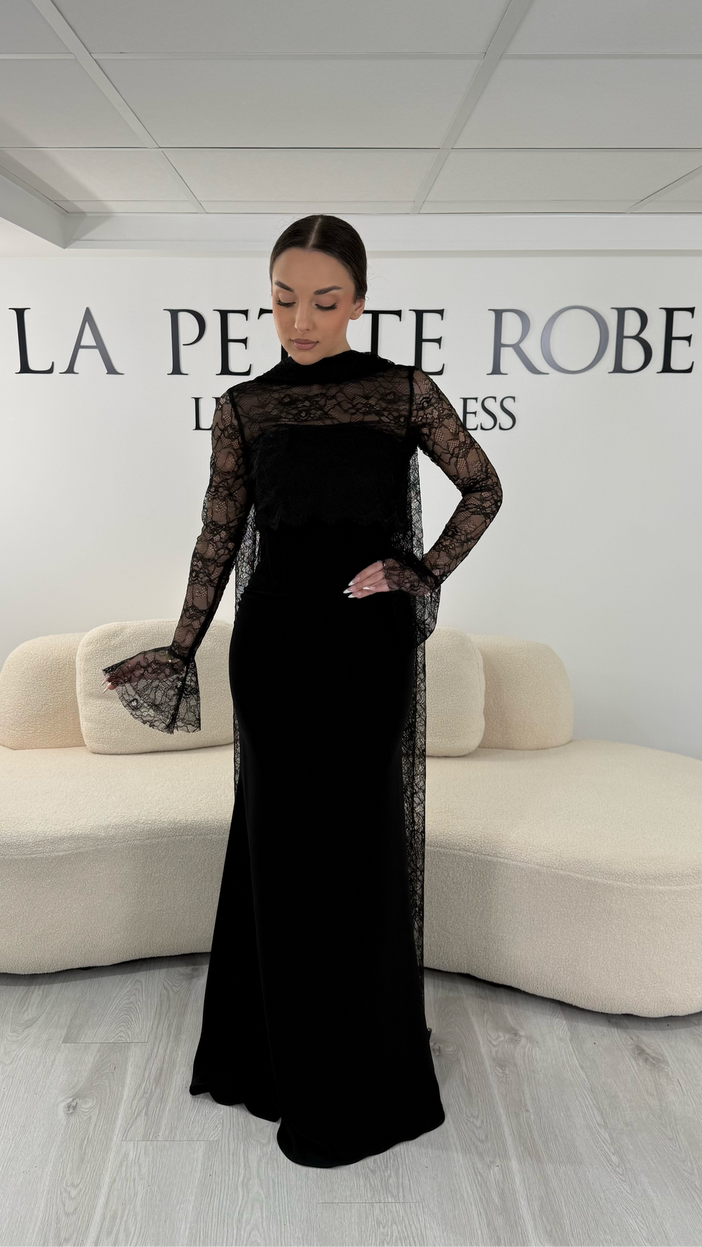 Robe de soirée noire élégante avec boléro en dentelle amovible et écharpe assortie. Robe longue sans fente idéale pour cérémonie et soirée chic.