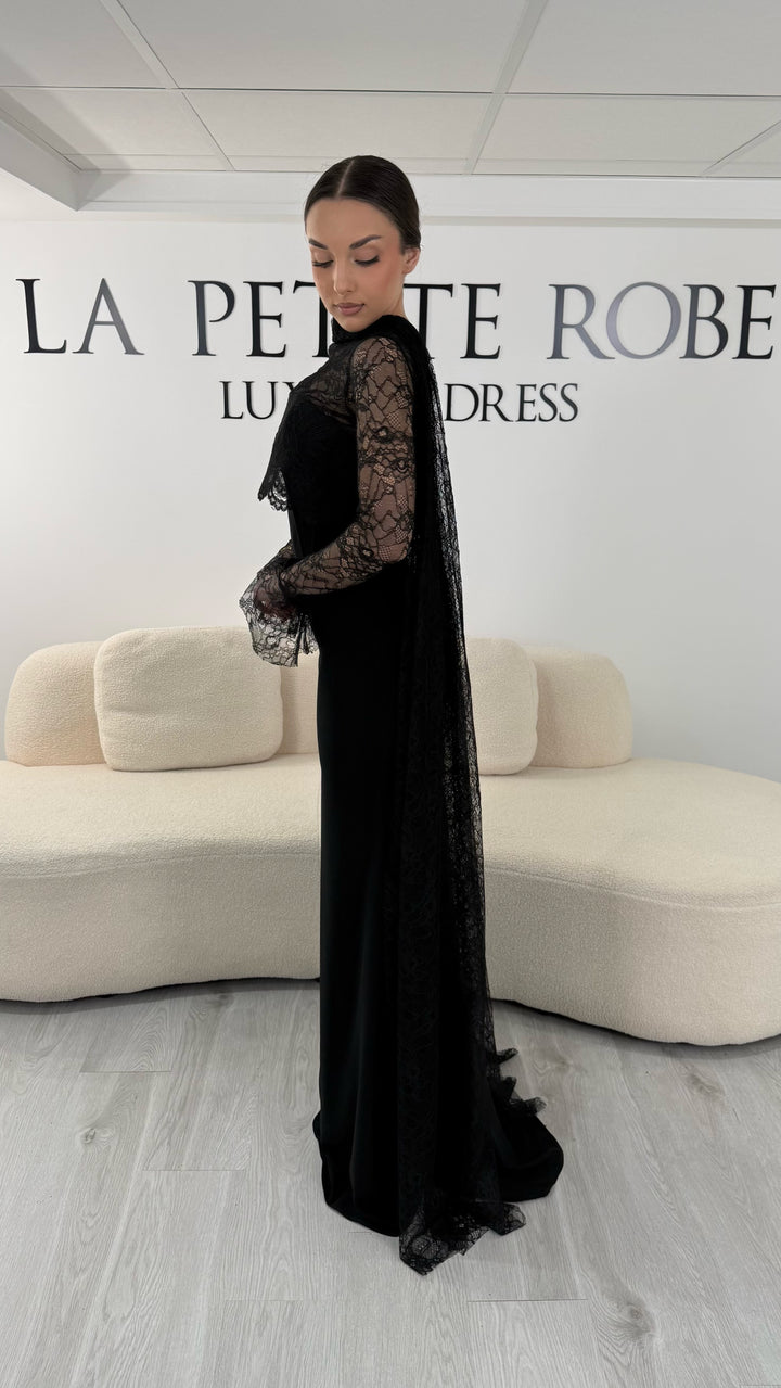 Robe de soirée noire élégante avec boléro en dentelle amovible et écharpe assortie. Robe longue sans fente idéale pour cérémonie et soirée chic.