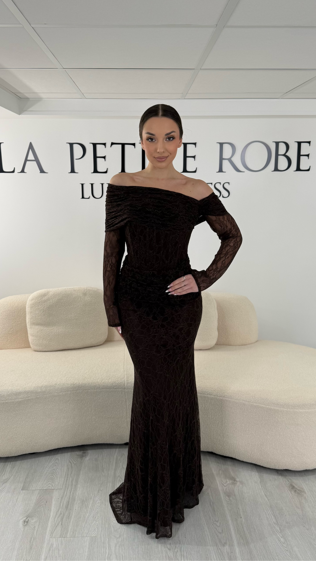 Robe de soirée marron en dentelle avec col bardot et manches longues. Robe longue élégante sans fente idéale pour soirée chic.