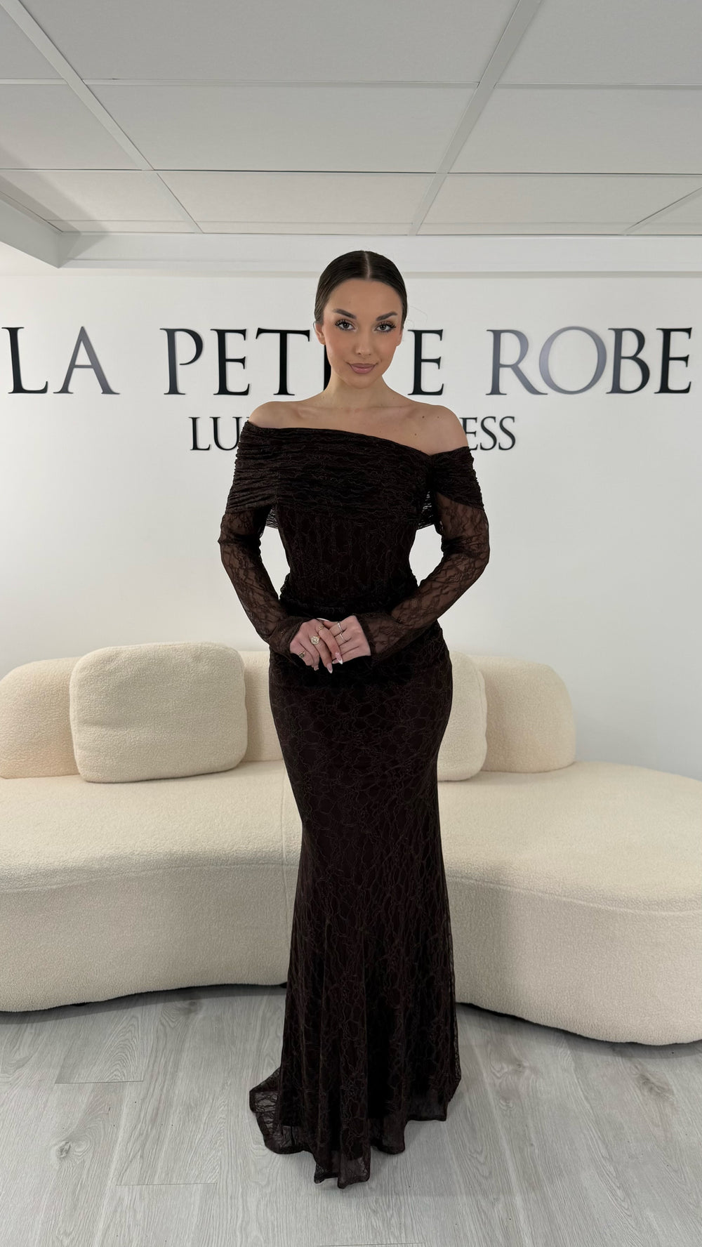Robe de soirée marron en dentelle avec col bardot et manches longues. Robe longue élégante sans fente idéale pour soirée chic.
