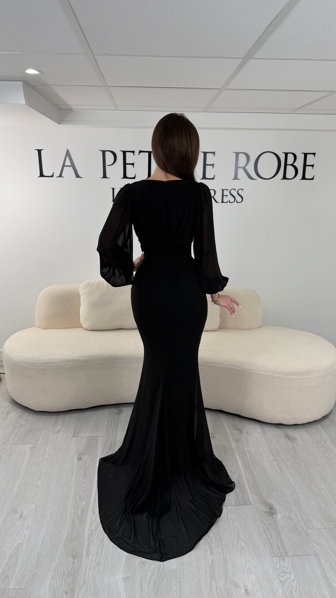 Robe de soirée noire longue, sans fente, avec col cache-cœur et manches longues fluides. Élégante pour vos soirées et cérémonies.
