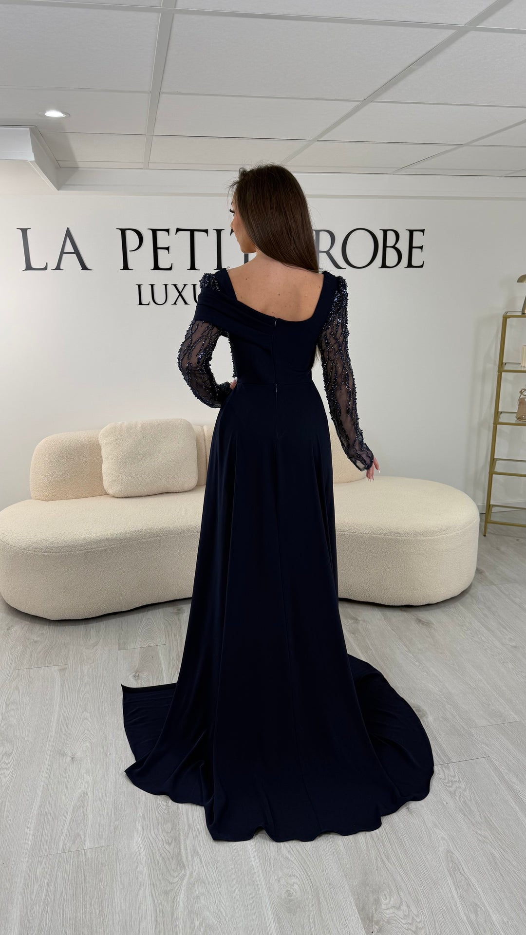 Robe de soirée bleu marine longue, sans fente, avec col carré et manches longues transparentes brodées. Élégante pour vos soirées.