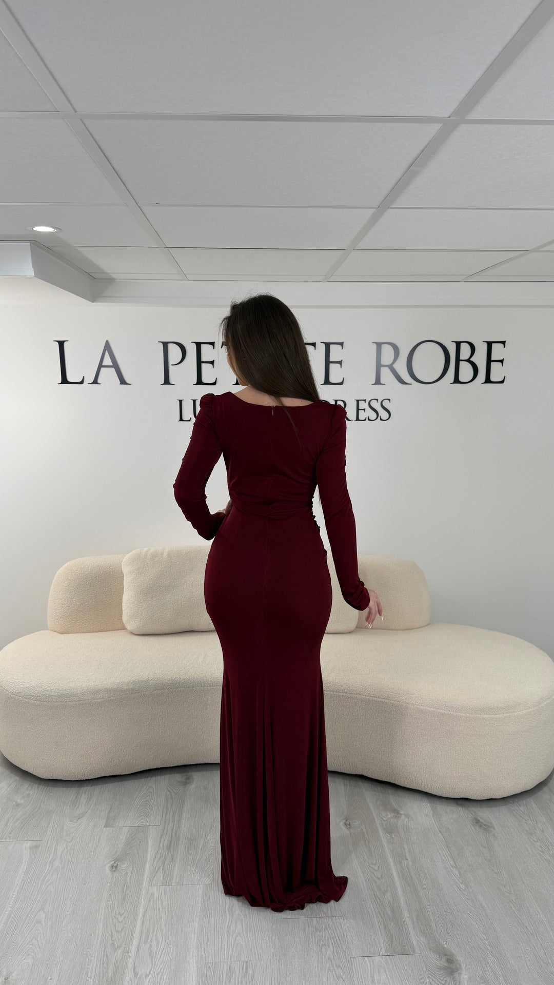 Robe de soirée bordeaux longue avec fente, col droit et manches longues. Élégante avec détails perlés pour vos soirées chic.