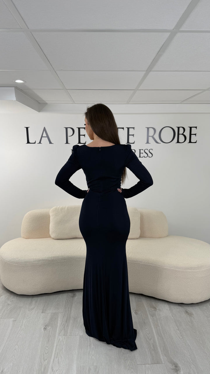 Robe de soirée bleu marine longue avec fente, col droit et manches longues. Élégante avec détails perlés pour vos soirées.