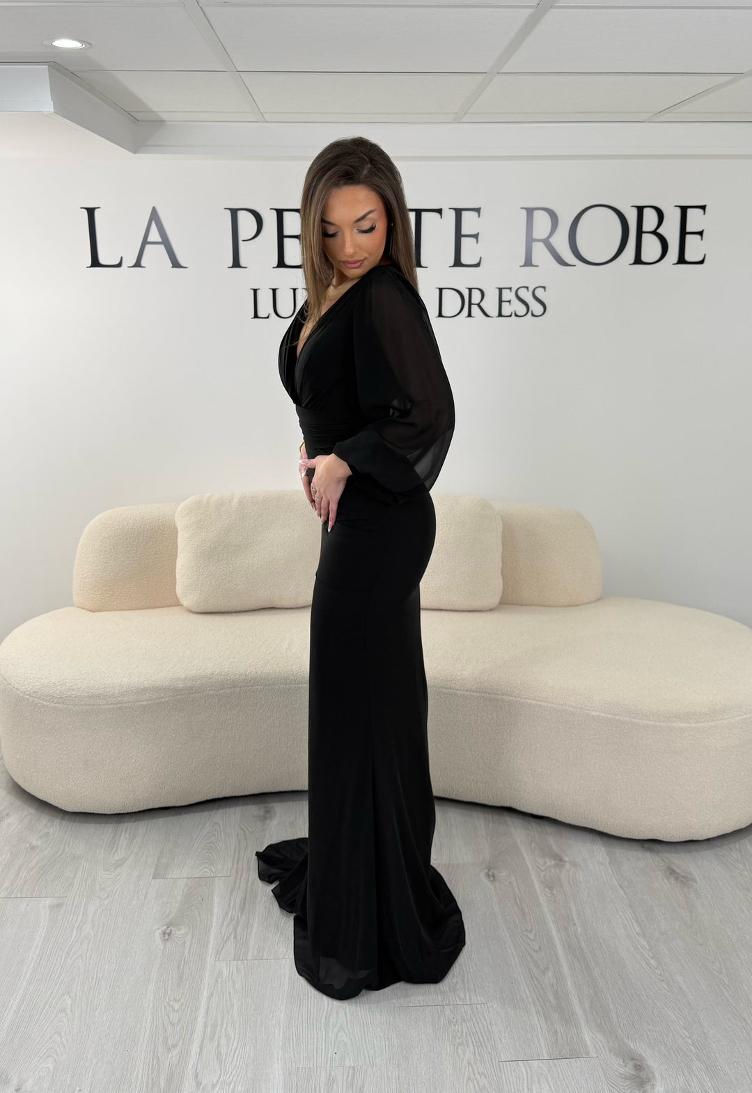 Robe de soirée noire longue, sans fente, avec col cache-cœur et manches longues fluides. Élégante pour vos soirées et cérémonies.