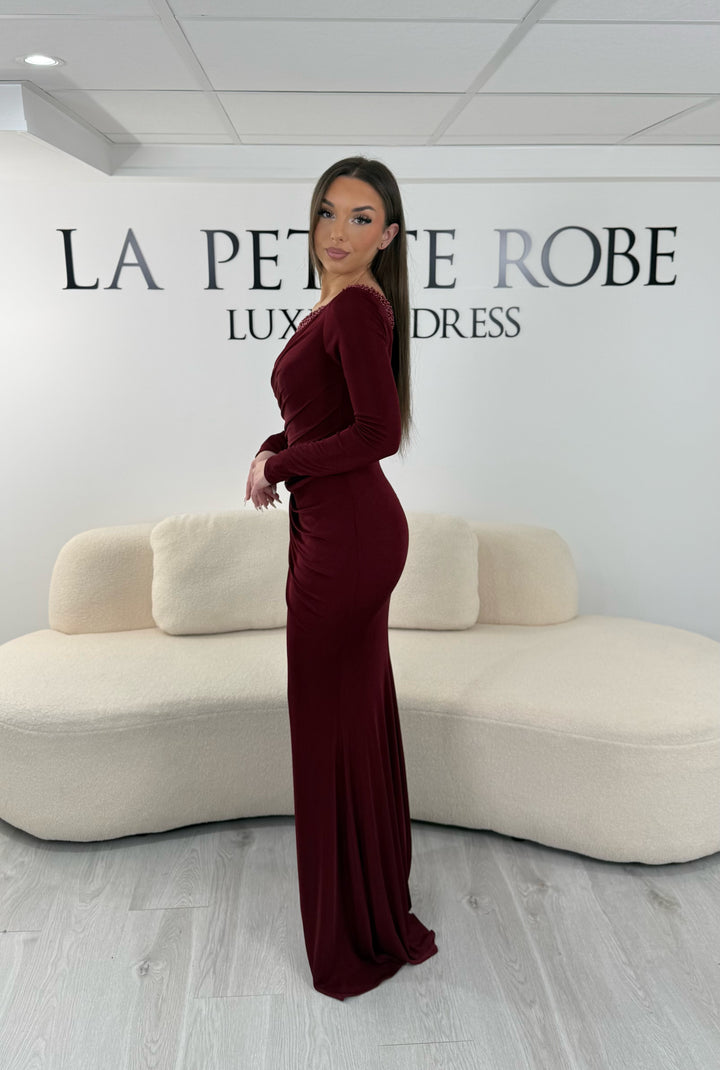 Robe de soirée bordeaux longue en jersey stretch, sans fente, avec col asymétrique et manches longues. Idéale pour vos soirées élégantes.
