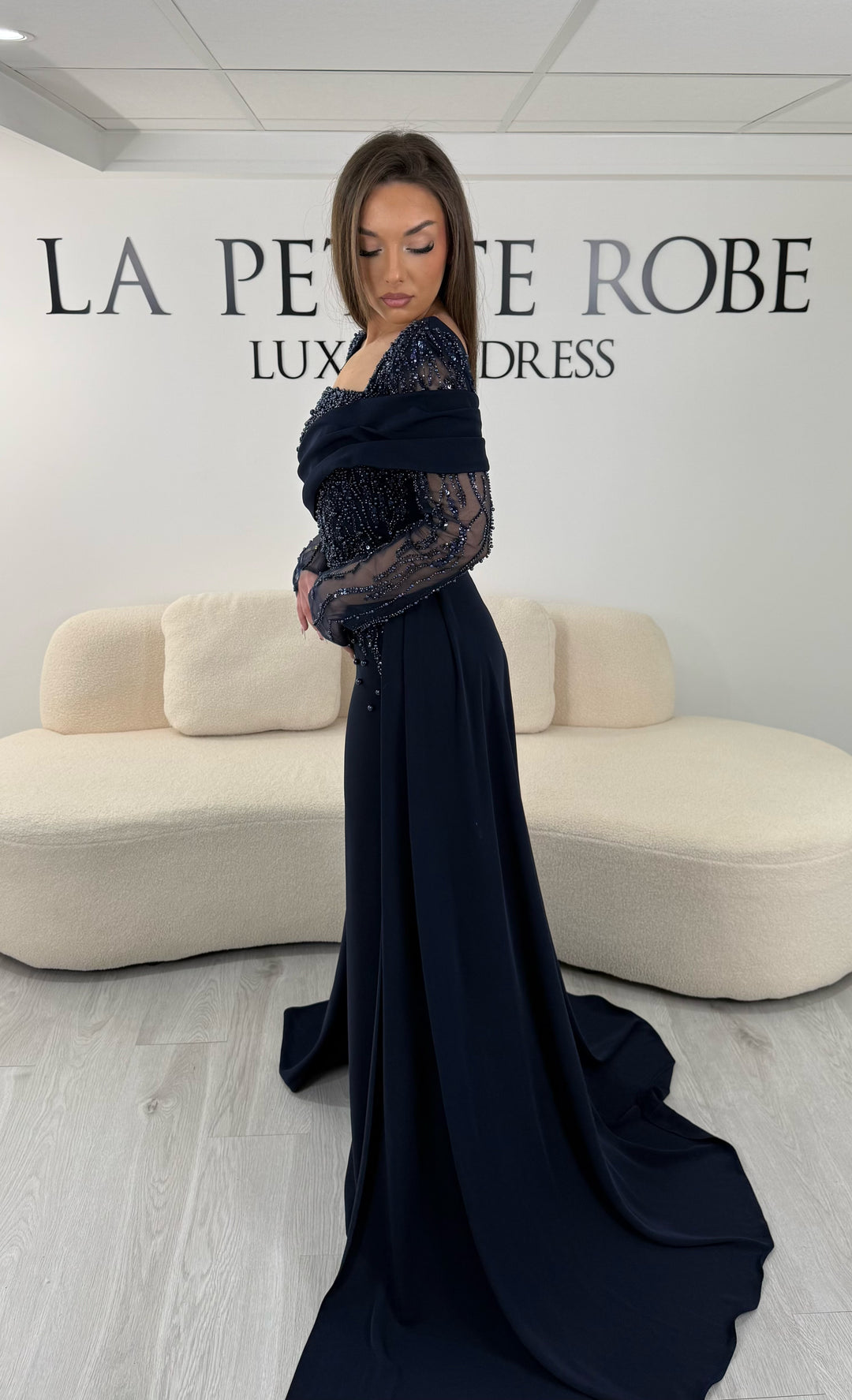 Robe de soirée bleu marine longue, sans fente, avec col carré et manches longues transparentes brodées. Élégante pour vos soirées.