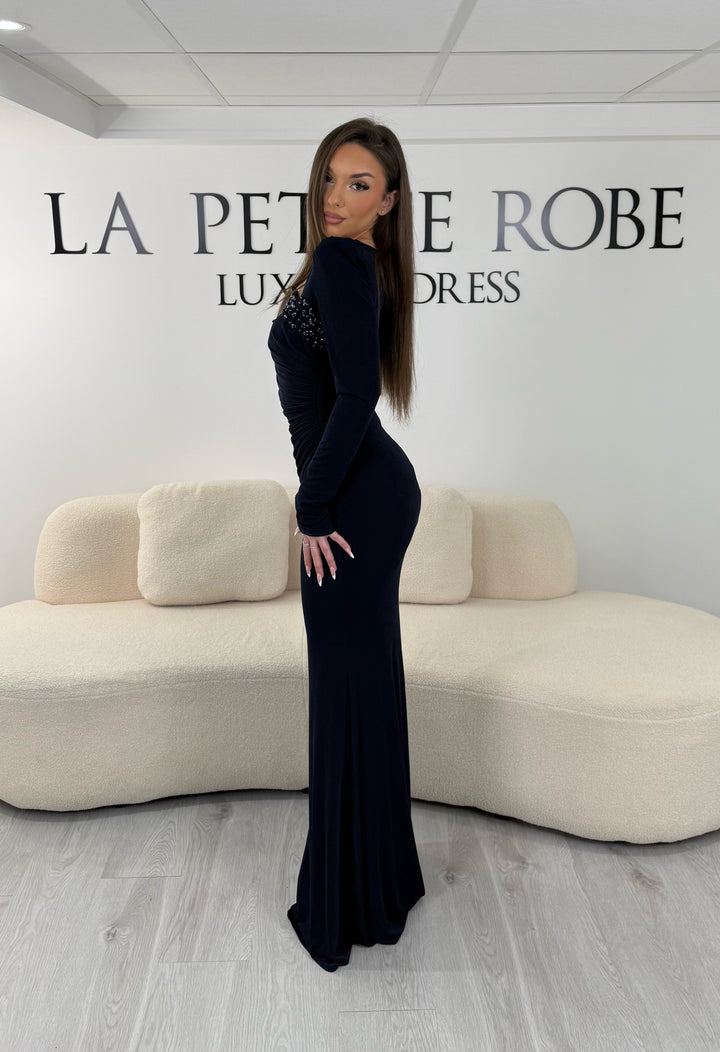 Robe de soirée bleu marine longue avec fente, col droit et manches longues. Élégante avec détails perlés pour vos soirées.