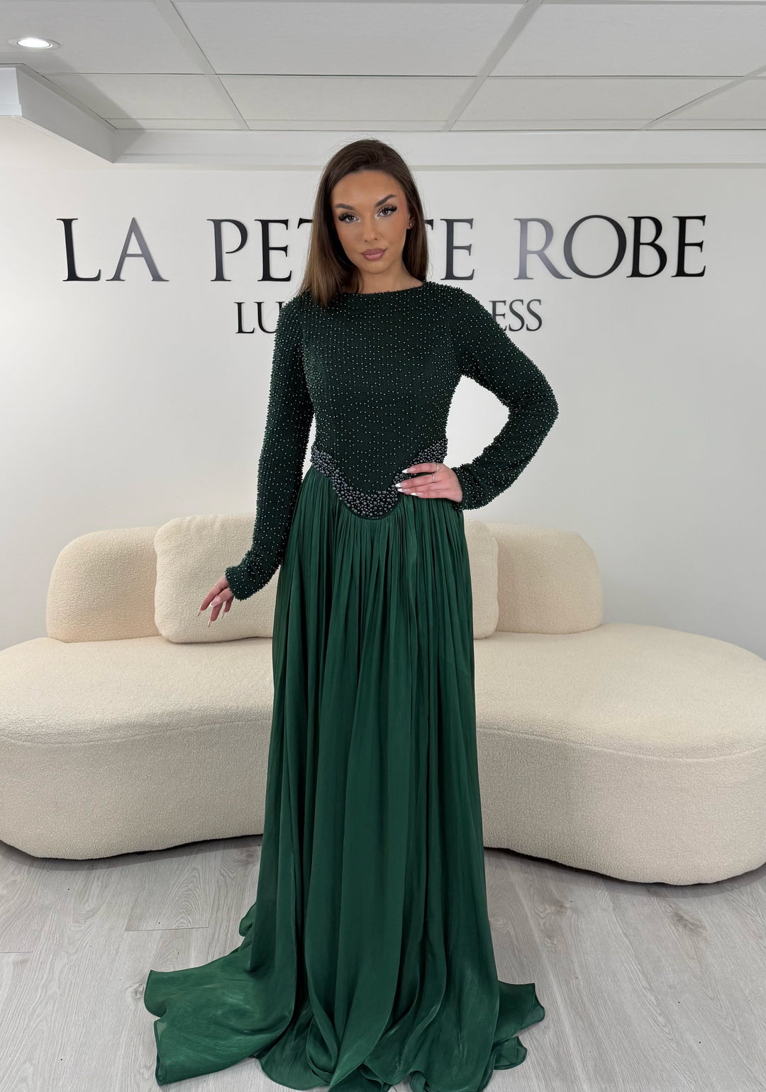 Robe de soirée vert émeraude longue, sans fente, avec col rond et manches longues. Élégante avec haut scintillant pour vos soirées.