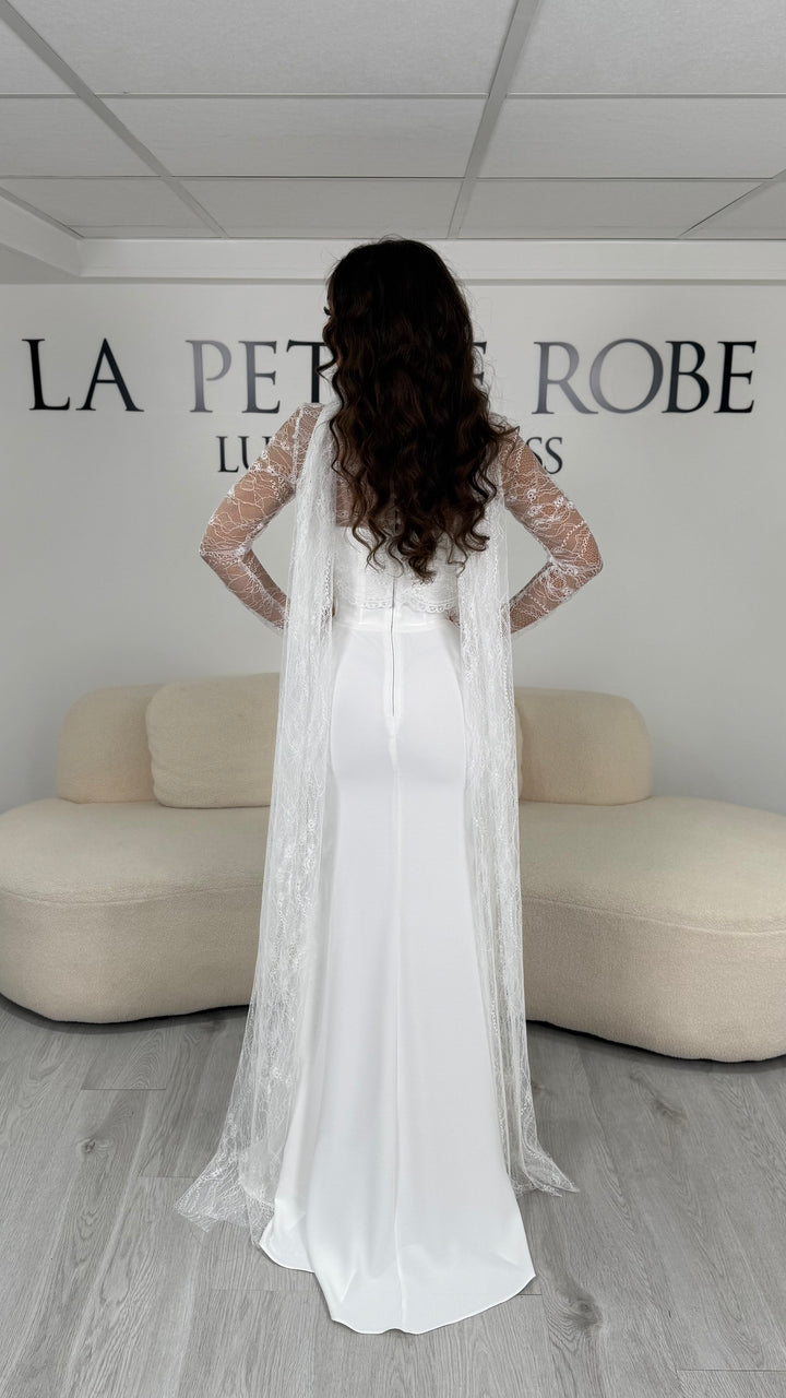 Robe de mariée blanche longue avec boléro amovible en dentelle, manches longues et col montant. Élégante, sans fente, idéale pour cérémonie et mariage.