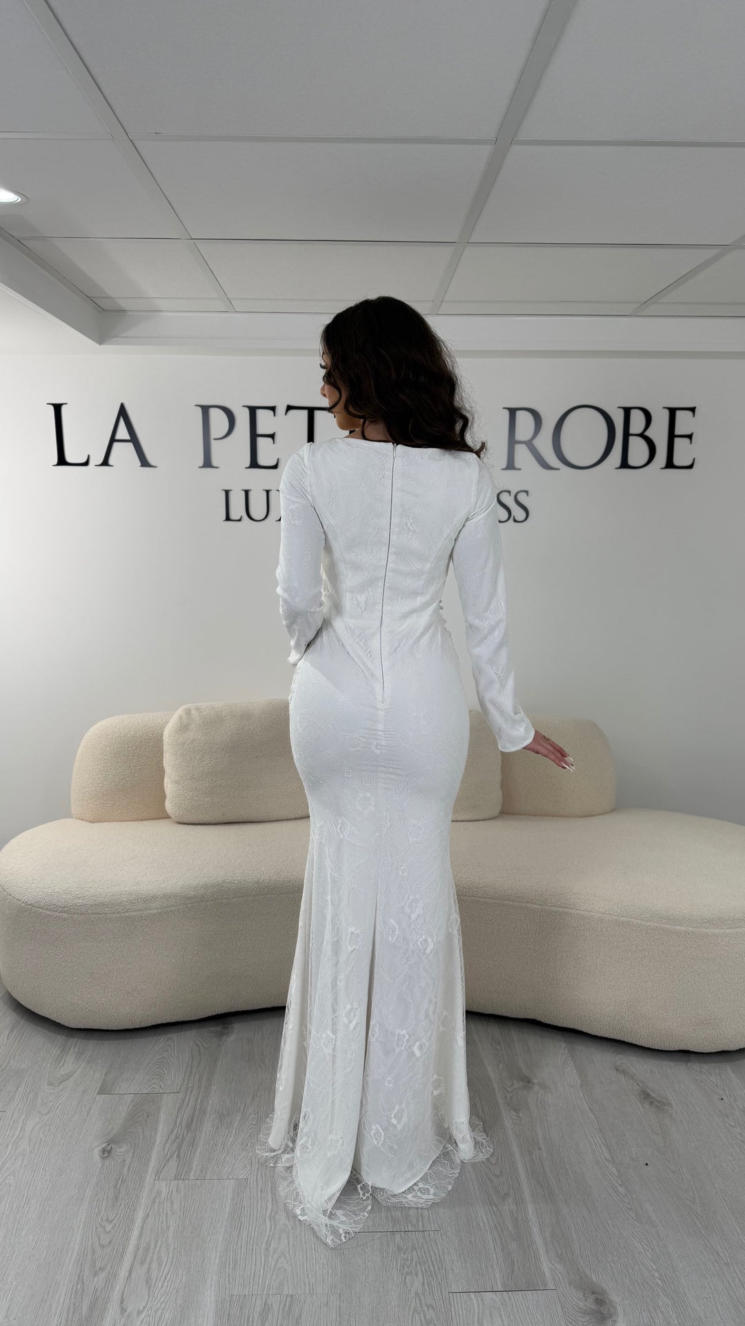 Robe de mariée blanche longue en dentelle perlée avec manches longues et col rond légèrement montant. Élégante, sans fente, idéale pour mariage.