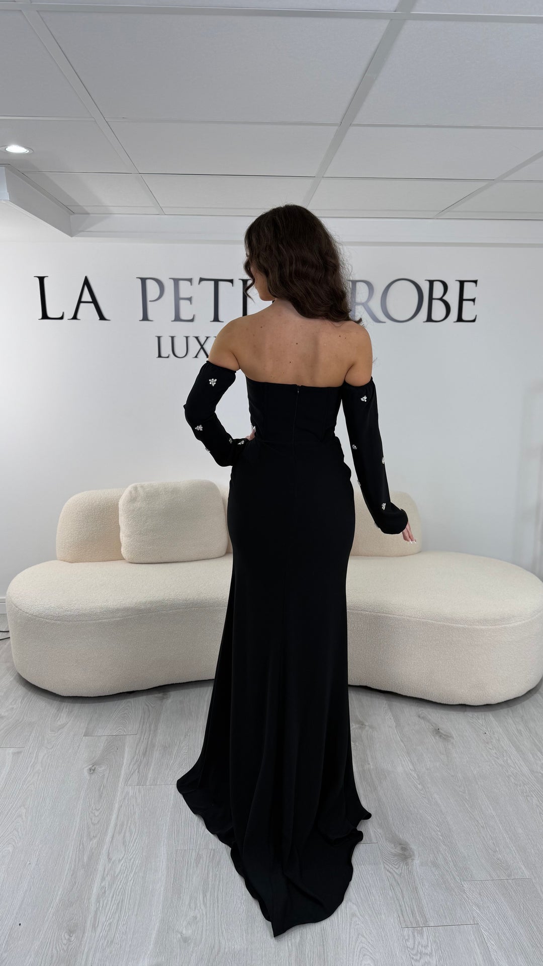 Robe de soirée noire longue avec fente, bustier et manches amovibles. Élégante et tendance 2026, idéale pour mariage ou demoiselle d’honneur.