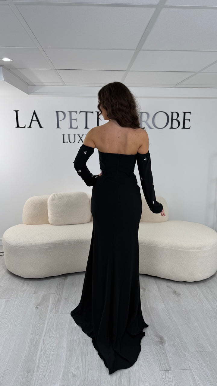 Robe de soirée noire longue avec fente, bustier et manches amovibles. Élégante et tendance 2026, idéale pour mariage ou demoiselle d’honneur.