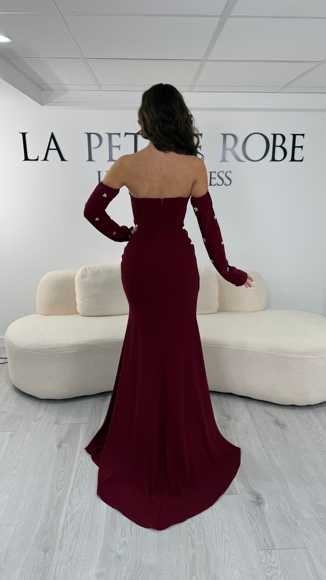 Robe de soirée bordeaux longue avec fente, bustier et manches amovibles. Élégante et tendance 2026, parfaite pour mariage ou soirée chic.