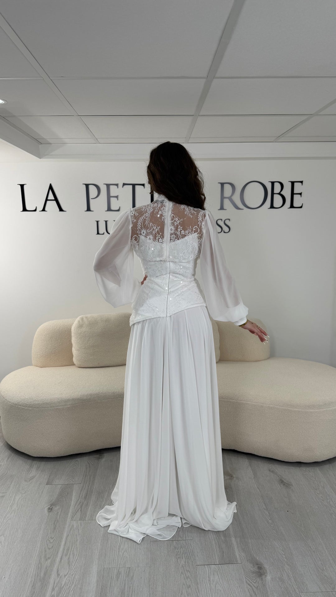 Robe de mariée blanche longue avec décolleté bustier sous col montant en dentelle et boléro amovible. Élégante, sans fente, idéale mariage 2026.